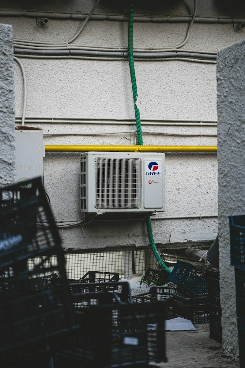 An outdoor air-conditioning unit with its fan grille and pipe connections