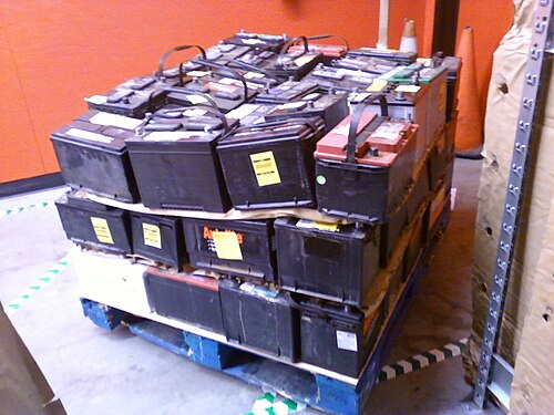 Used lead-acid batteries stacked on a pallet for recycling