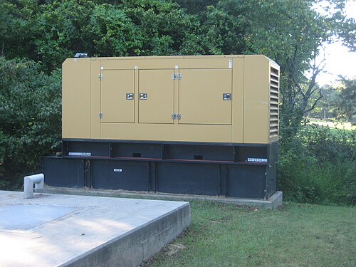 A large enclosed diesel generator on a concrete base outdoors
