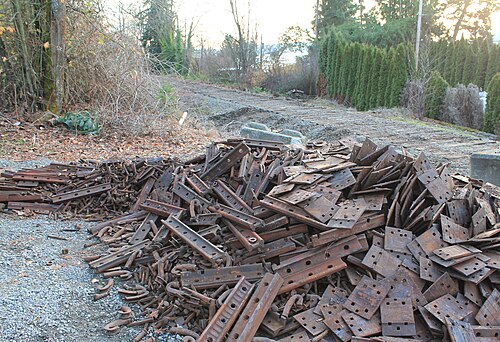 A pile of rusty steel brackets and rails separated for scrap