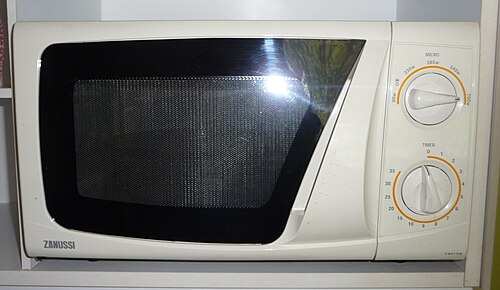 A white microwave oven with a dark door and two rotary controls