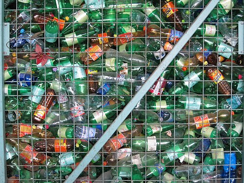 Used plastic bottles gathered in a metal recycling cage