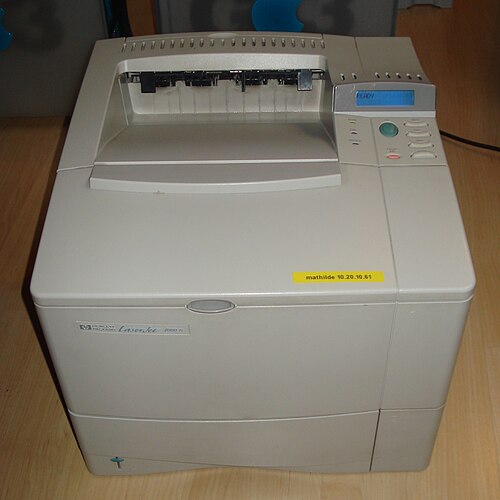 An older laser printer with its output tray and control panel visible