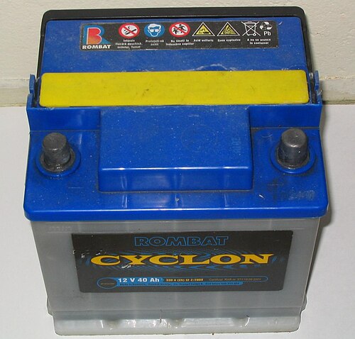 An intact vehicle battery with two top terminals and a blue and yellow casing